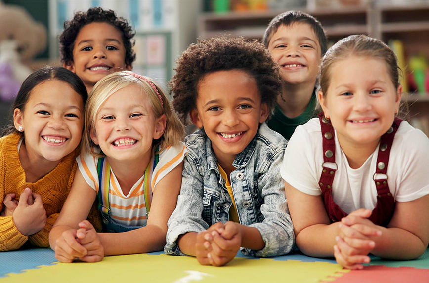image of a group of kids laying on the ground smiling